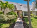 Inviting front entrance with brick walkway, lush landscaping, and an American flag at 3648 Beneva Oaks Blvd, Sarasota, FL 34238