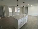 This newly remodeled kitchen features a center island, and wood-look tiling that compliments the neutral color pallet at 3826 Clover Ln, Sarasota, FL 34233
