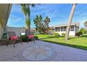 A tranquil patio with decorative concrete design surrounded by lush lawn and mature trees in the backyard at 390 301 W Blvd # 13A, Bradenton, FL 34205