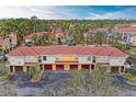 An aerial view showcases a multi-unit residential complex with well-maintained landscaping, tile roofs, and private garages at 4761 Travini Cir # B102, Sarasota, FL 34235