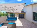 A charming patio area with pavers, comfortable seating, and an umbrella for shade at 5901 La Vista Ln, Bradenton, FL 34210