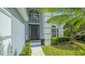 Stunning home entry featuring a grand two-story foyer with transom windows and mature landscaping at 6433 Blue Grosbeak Cir, Lakewood Ranch, FL 34202