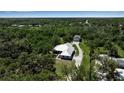Stunning aerial view of a home nestled in lush greenery, featuring a metal roof and a detached garage at 6510 24Th E Ave, Bradenton, FL 34208