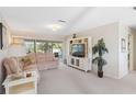 Cozy living room featuring plush sofa, neutral carpet and a view to the outside, creating an inviting and relaxing atmosphere at 6812 19Th W Ave, Bradenton, FL 34209