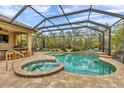 Enclosed backyard with large pool, hot tub, outdoor kitchen, and ample seating area at 8224 Larkspur Cir, Sarasota, FL 34241