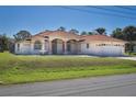 Beautiful single-story home with a red tile roof, arched windows, fountain and lush front lawn at 108 Mccabe St, Port Charlotte, FL 33953