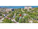 An aerial view showcases a home surrounded by lush greenery and a glimpse of the bay at 1135 Florida Ave, Sarasota, FL 34236