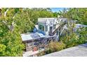 Back of house showing sunroom, and rooftop deck surrounded by lush trees at 1135 Florida Ave, Sarasota, FL 34236