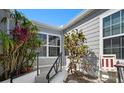 Inviting front entrance with tropical plants, stairs, and nice window trim for a touch of elegance at 1218 Spoonbill Landings Cir, Bradenton, FL 34209