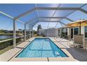 Screened in pool with patio furniture, waterfront views, and clear blue water at 2502 Larkspur Dr, Punta Gorda, FL 33950