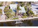 Aerial view showcasing home's canal-front location, boat lift, lush surroundings and private outdoor space at 288 Island Cir, Sarasota, FL 34242