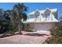 Inviting two-story home with a well-manicured lawn, two-car garage and upper-level balconettes at 288 Island Cir, Sarasota, FL 34242