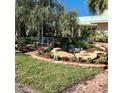 Beautifully landscaped front yard with colorful flowers, large stones, and a charming brick walkway at 288 Island Cir, Sarasota, FL 34242