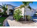 Charming front entrance with a brick walkway, lush landscaping, and a well-maintained lawn at 2962 Trustee Ave, Sarasota, FL 34243