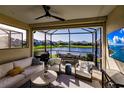 Relaxing screened lanai featuring comfortable seating, dining area, and serene lake views at 2962 Trustee Ave, Sarasota, FL 34243