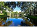 Scenic view of a tranquil pond surrounded by mature trees and well-manicured grounds at 315 30Th W Ave # B214, Bradenton, FL 34205