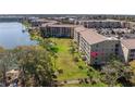 Aerial view of condo building with mature landscaping and lake views showing assigned parking spots at 3664 Lake Bayshore Dr # K323, Bradenton, FL 34205