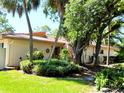 Charming single-story home with a terracotta tile roof and lush, mature landscaping with palm trees and flowering shrubs at 3818 Sun Eagle Ln, Bradenton, FL 34210