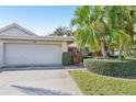 Charming home exterior featuring a well-manicured lawn, mature palm trees, and a two-car garage at 3880 Wilshire Cir # 28, Sarasota, FL 34238