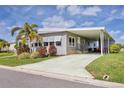 Well-kept home featuring an expansive driveway, carport, lush lawn, and attractive exterior paint at 4304 14Th E St, Ellenton, FL 34222