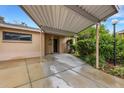 Exterior view of covered driveway leading to front entrance, complemented by well-maintained landscaping at 5019 Village Gardens Dr # 31, Sarasota, FL 34234