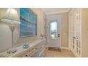 Inviting home entrance with a decorative console table, stylish lamp, and elegant front door with glass accents at 5361 Sundew Dr, Sarasota, FL 34238
