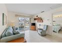 Cozy living room with sliding glass doors, tile floors, and comfortable blue furnishings at 902 Gibbs Rd # 282, Venice, FL 34285