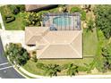 Aerial view of backyard featuring a screened-in pool and beautiful landscaping around the home at 9734 51St Terr E, Bradenton, FL 34211
