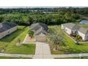 Aerial view of a well-maintained home featuring lush landscaping, a paved driveway, and a serene neighborhood setting at 9767 50Th Street E Cir, Parrish, FL 34219
