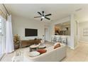 Bright living room features modern decor, tile floors, a ceiling fan and sliding glass doors to the outdoor patio at 9767 50Th Street E Cir, Parrish, FL 34219