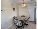 Cozy dining area with glass table, chandelier, and door leading to the outside at 1036 Hope St, Venice, FL 34285