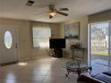 Bright living room featuring tile flooring, a ceiling fan, and a glass door to a screened in lanai at 1036 Hope St, Venice, FL 34285