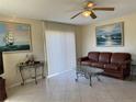 Comfortable living room with tile flooring, ceiling fan, and sliding glass doors for natural light at 1036 Hope St, Venice, FL 34285