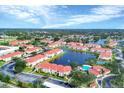Scenic aerial view of the community's condos surrounding a tranquil lake and featuring a refreshing pool at 1110 Villagio Cir # 103, Sarasota, FL 34237