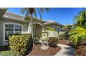 Inviting front entrance with lush landscaping, a stone pathway, and a charming covered porch at 129 Wayforest Dr, Venice, FL 34292
