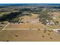 Aerial view of a property featuring fenced pastures and open land, defined by a white boundary line at 15101 Rawls Rd, Sarasota, FL 34240