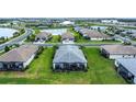 Aerial view of a home with a screened-in patio and lush green lawn in a well-planned community at 16111 Sunny Day Dr, Bradenton, FL 34211