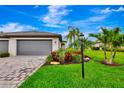 Charming home featuring a paved driveway, well-maintained lawn, and vibrant landscaping, perfect for curb appeal at 16111 Sunny Day Dr, Bradenton, FL 34211
