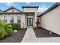 Attractive front entrance with stone walkway, manicured landscaping and covered entry at 17519 Polo Trl, Lakewood Ranch, FL 34211