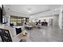 Spacious living room with modern furnishings, tile flooring, and a view of the outdoor space at 17519 Polo Trl, Lakewood Ranch, FL 34211