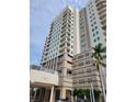 Beautiful condominium building featuring multiple balconies, a portico, and lush landscaping at 1771 Ringling Blvd # 902, Sarasota, FL 34236