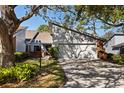 View of the front of the house with attached garage, driveway, and mature landscaping at 2626 Moss Oak Dr # 51, Sarasota, FL 34231