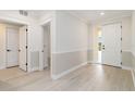 Bright hallway featuring white trim, light wood floors, and multiple doorways at 280 Hidden Bay Dr # 202, Osprey, FL 34229