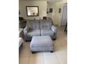 Cozy seating area with a gray love seat and ottoman, perfect for relaxing at 3013 Yarmouth W Dr, Bradenton, FL 34205