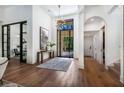 Grand foyer with a decorative light fixture, hardwood floors, and a large window offering natural light at 329 Bird Key Dr, Sarasota, FL 34236