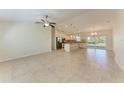 Spacious living room seamlessly connects to a modern kitchen, enhanced by tile flooring and natural light at 3437 Circleville St, North Port, FL 34286