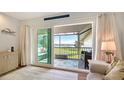 Bright living room with sliding glass doors leading to a screened lanai overlooking the water at 4234 Gulf Of Mexico Dr # Q2, Longboat Key, FL 34228