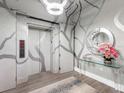 Elegant condo hallway with unique wall art, sleek lighting and elevator access at 540 N Tamiami Trl # 1503, Sarasota, FL 34236