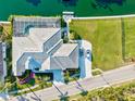 Expansive waterfront home featuring a screened pool, private dock, lush landscaping, and a spacious driveway at 556 Regatta Way, Bradenton, FL 34208