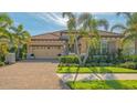 Inviting single-story home with a barrel tile roof, three-car garage, and well-manicured landscaping at 7213 Whittlebury Trl, Lakewood Ranch, FL 34202